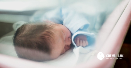 Newborn baby in a hospital bassinet.